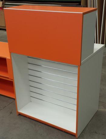 Custom orange retail counter with slatwall display on front 