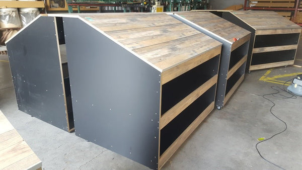 Wooden retail display case with shelving in a warehouse setting