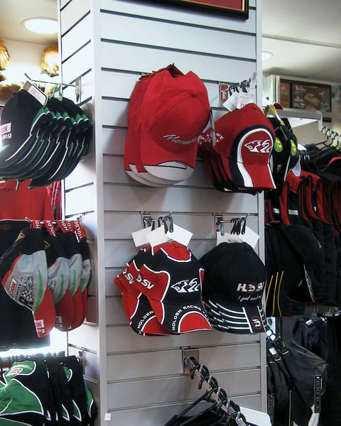 Plankwall® 75mm pitch aluminium slatwall panels installed as a continuous retail wall display with hats