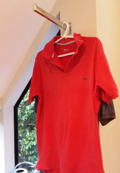photo of hanging red shirt and laundry drying on straight wall mount arm bracket at home 